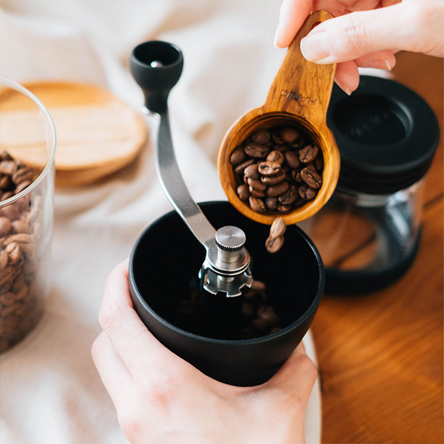Hario Skerton N Handkaffeemühle mit hochwertigem Keramikmahlwerk und stabiler Handkurbel beim Befüllen