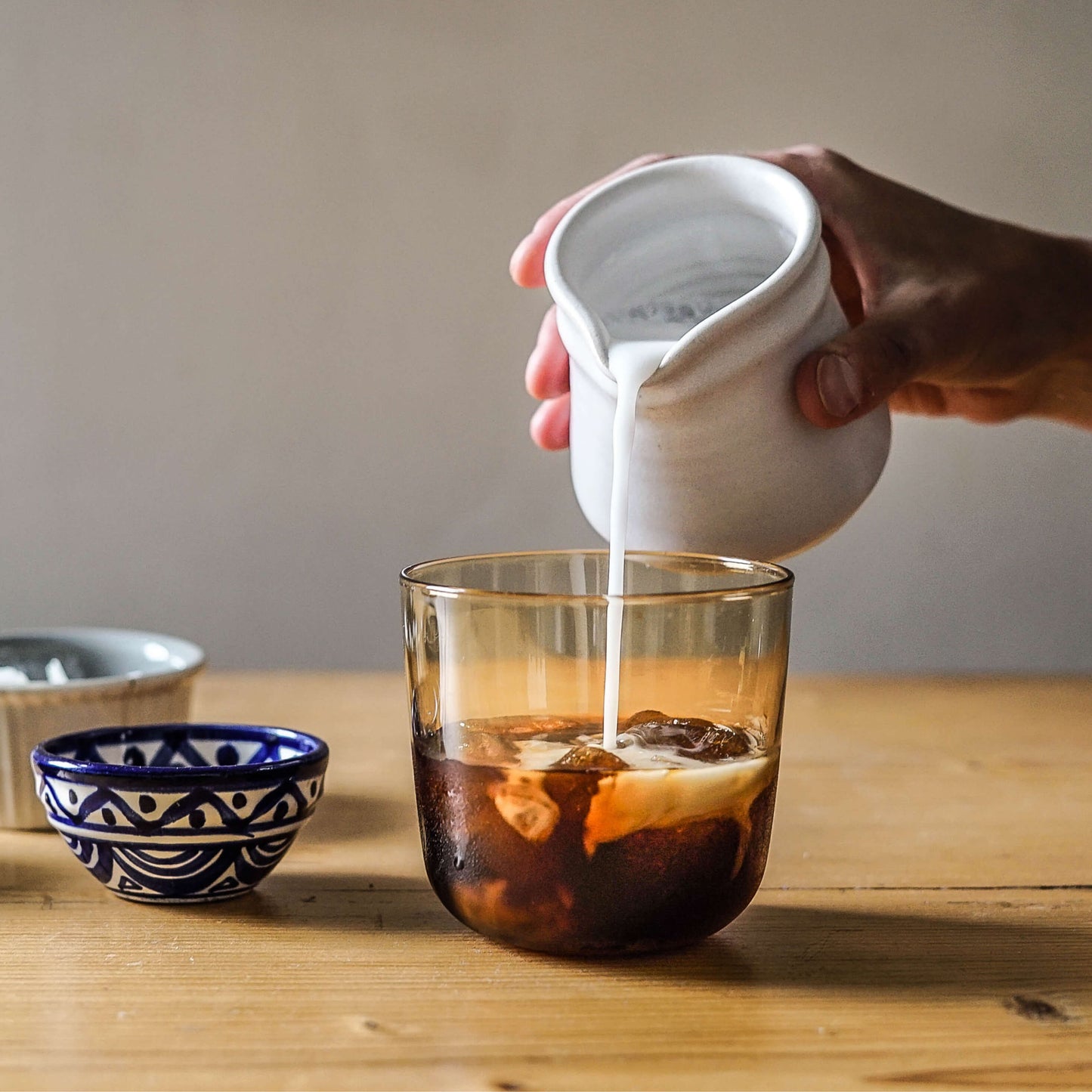 Kaffee für Cold Brew im Set mit Milch wird in Glas gegossen, ideal für selbstgemachten Cold Brew.
