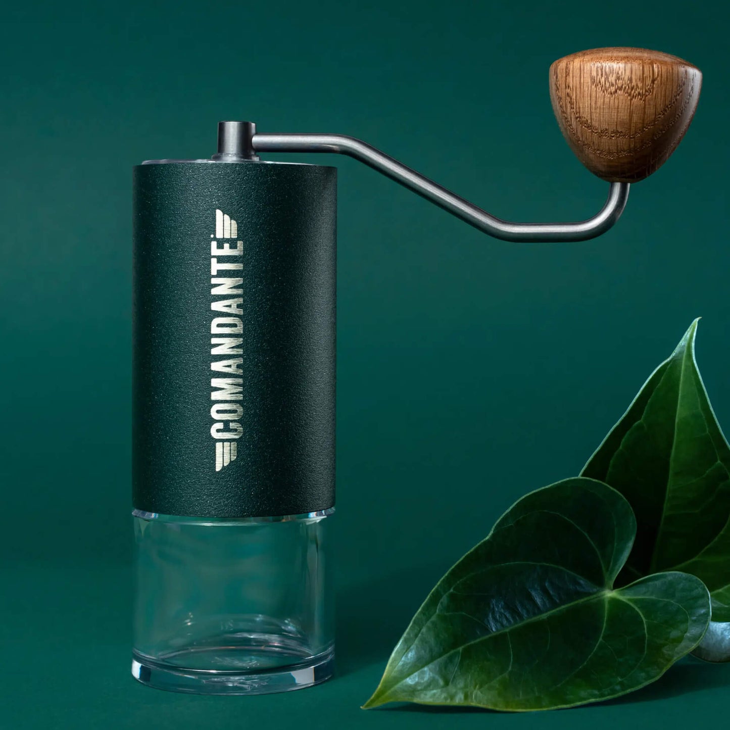 Comandante C40 MK4 Nitro Blade Kaffeemühle mit Holzgriff und klarem Mahlbehälter vor grünem Hintergrund