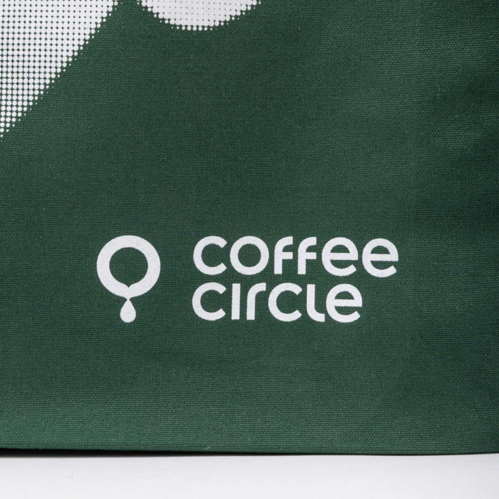 Coffee Circle Tote Bag aus robustem, 100% Fairtrade Baumwollmaterial mit weißem Logo auf grünem Hintergrund.