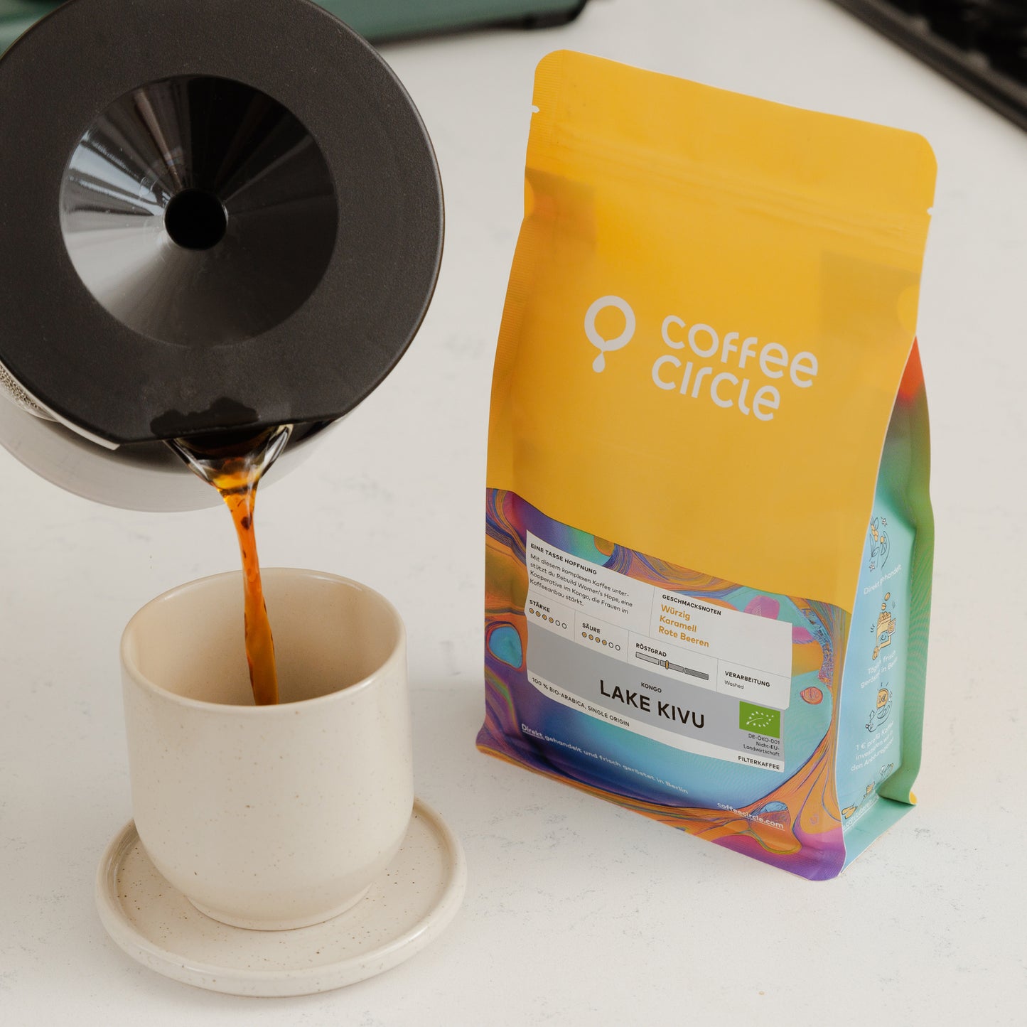 Lake Kivu Kaffee Packung neben Tasse mit frisch aufgebrühtem Kaffee und Kaffeezubereiter