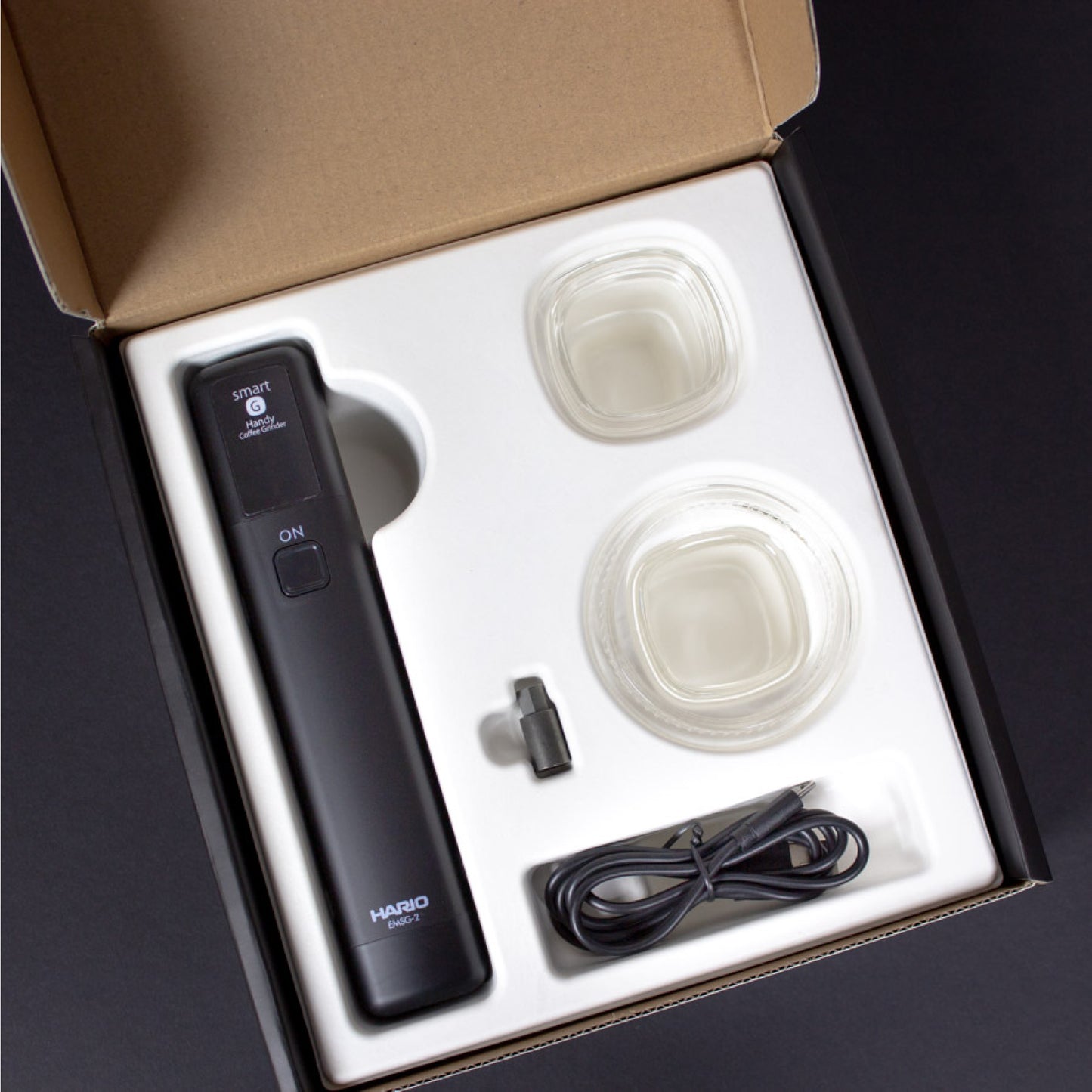 Hario Mobile Mill Stick + Comandante Adapter mit Ladegerät und Zubehör im offenen Verpackungskarton