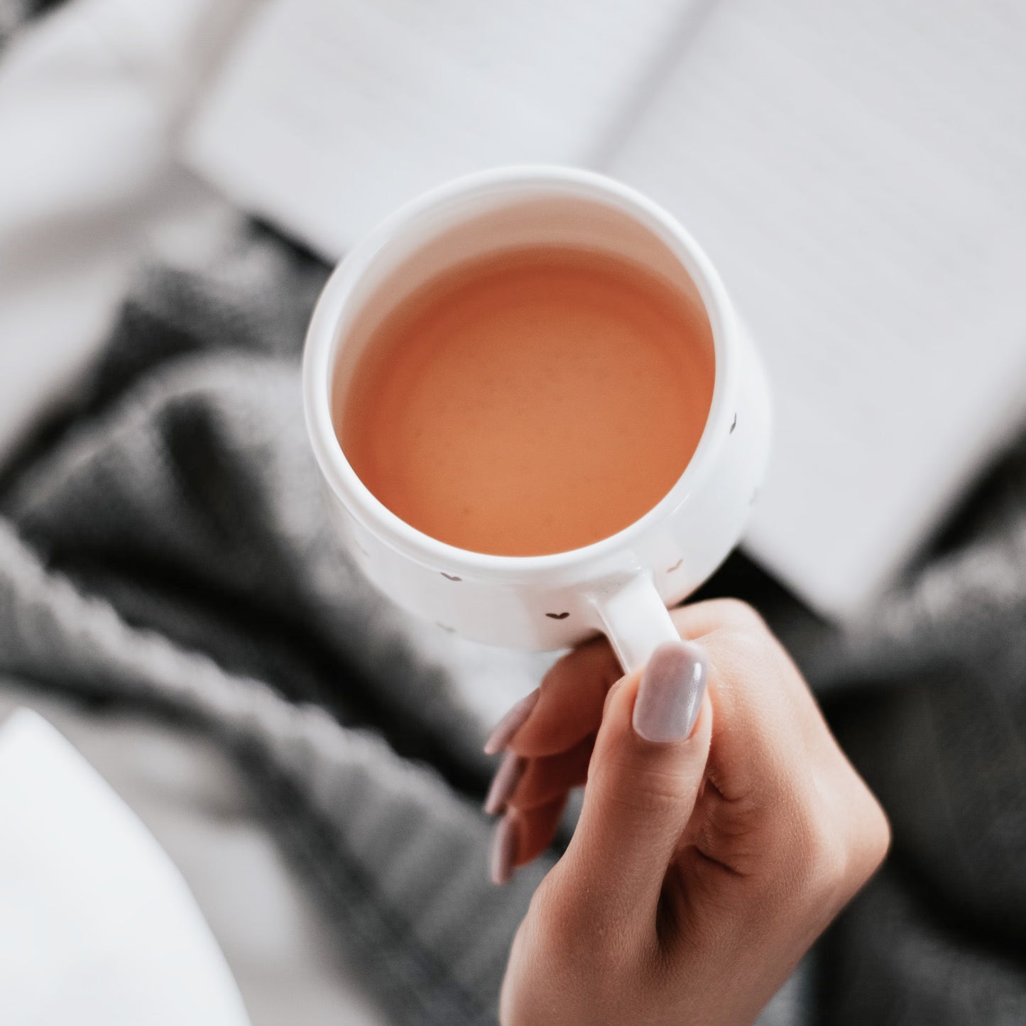 Hand hält Tasse mit warmem Cascara Tee, Naturgetränk aus getrockneten Kaffeeschalen – Cascara Tee.