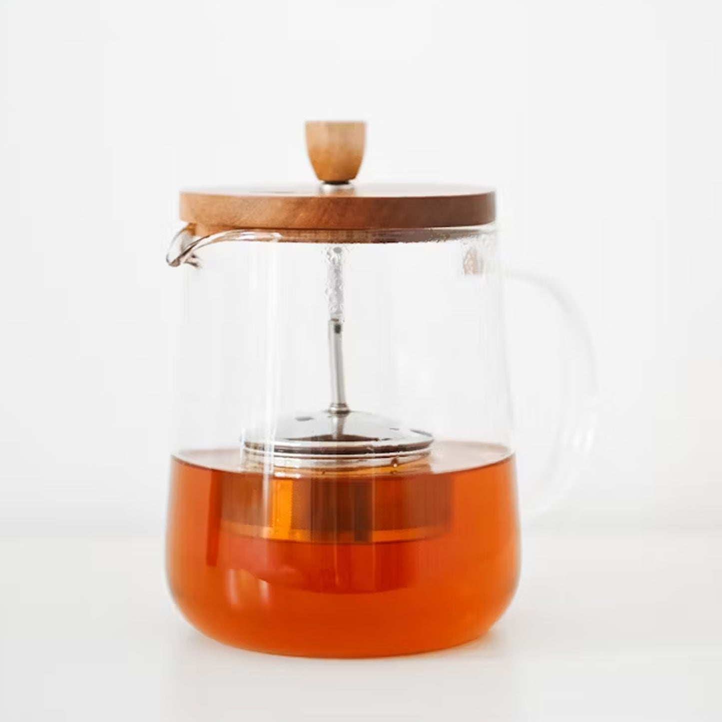 Cascara Tee in einer modernen Glas-Teekanne mit Holzdeckel, zubereitet aus getrockneten Kaffeeschalen.