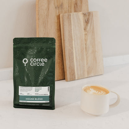 Grüner Coffee Circle Espresso House Blend Beutel neben Cappuccino auf weißer Arbeitsfläche